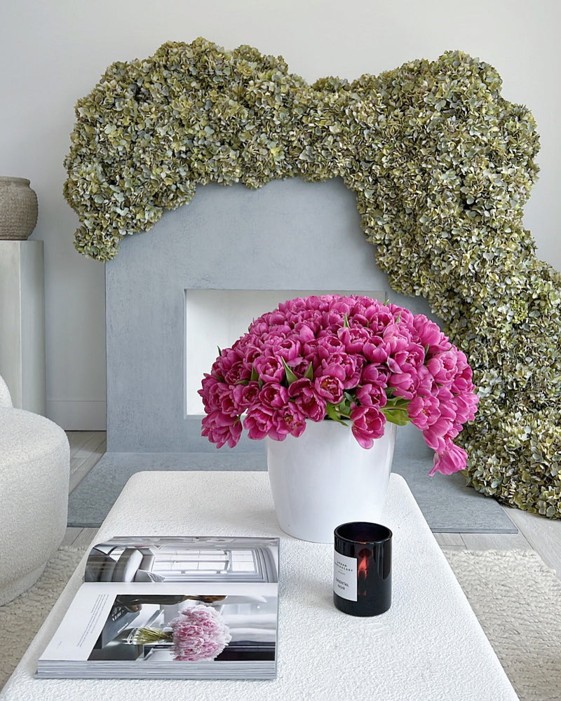 Luxury floral arrangement displayed on a coffee table with a floral installation on a mantel. 